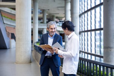 Üniversitede eğitim, akademik ve iş konsepti fakültesinde otururken, Asyalı son sınıf profesörü üniversite öğrencilerine araştırma tezi hakkında tavsiyelerde bulunuyor.