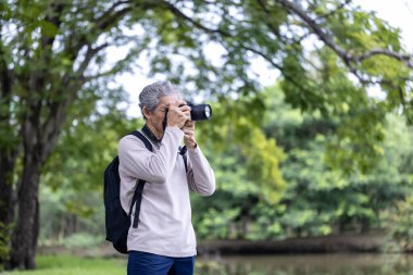 Asya 'nın son sınıf öğrencisi ormanda yürürken aynı zamanda yaşlılara özel bir egzersiz ve doğa terapisi için fotoğraf çekiyor.