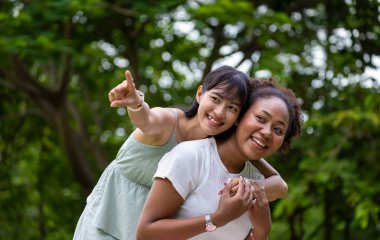 LGBTQ + Lezbiyen çifti yaz konsepti süresince halka açık parkta boş zamanlarının tadını çıkarırken gülüyor ve sarılıyorlar.