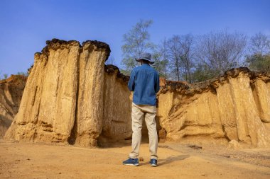 Asyalı jeolog, toprak ananın kavramını anlamak için bilimsel araştırma ve arkeoloji için doğal kumtaşı kanyonu taş ocağı kaynağındaki örnek kayayı araştırıyor ve inceliyor.