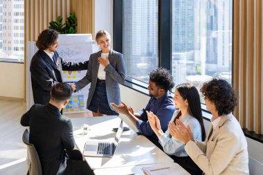 Team of diversity business people having agreement and handshake deal over new strategic strategy project on investment real estate with recognition and applause from other colleague for partnership clipart