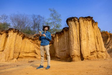 Asyalı jeolog, toprak ananın kavramını anlamak için bilimsel araştırma ve arkeoloji için doğal kumtaşı kanyonu taş ocağı kaynağındaki örnek kayayı araştırıyor ve inceliyor.