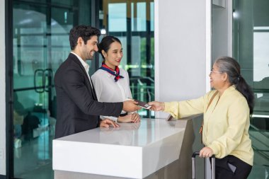 Asya kıdemli yolcusu uçağa binmeden önce son bir kontrol için uçuş kapısında bulunan havayolu ekibine giriş kartını gösteriyor.