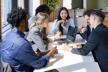 Çeşitli iş adamları, yeni proje ve planlama için modern ofis binasında çalışırken yatırım gayrimenkulleri üzerine yeni stratejik strateji projesi üzerinde tartışıyorlar.