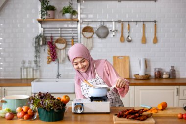 Mutlu Arap Müslüman ev hanımı, Orta Doğu 'daki evde lezzetli helal yemekler ve Ramazan ayından sonra bayram bayramı için İran mutfağı yemeği hazırlıyor ve pişiriyor.