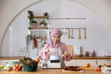 Mutlu Arap Müslüman ev hanımı, Orta Doğu 'daki evde lezzetli helal yemekler ve Ramazan ayından sonra bayram bayramı için İran mutfağı yemeği hazırlıyor ve pişiriyor.