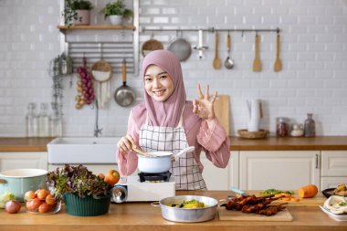 Mutlu Arap Müslüman ev hanımı, Orta Doğu 'daki evde lezzetli helal yemekler ve Ramazan ayından sonra bayram bayramı için İran mutfağı yemeği hazırlıyor ve pişiriyor.