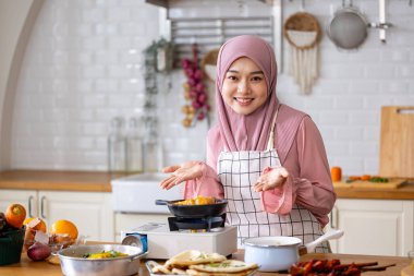 Mutlu Arap Müslüman ev hanımı, Orta Doğu 'daki evde lezzetli helal yemekler ve Ramazan ayından sonra bayram bayramı için İran mutfağı yemeği hazırlıyor ve pişiriyor.