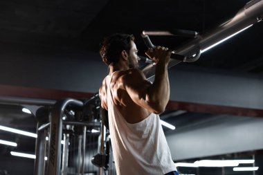 Kafkas kaslı sporcu portresi. Mükemmel karın kasları ve spor salonunda kaslı. Egzersiz için arka planı koyu ve yüksek kontrastlı düşük ayarlı ışık stüdyosunda egzersiz yapıyor.