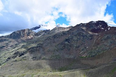 Güzel dağ manzarası, gökyüzünde bulutlar, karlı zirveler.