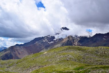 Bulutları ve yüksek karlı zirvesi olan güzel bir dağ manzarası