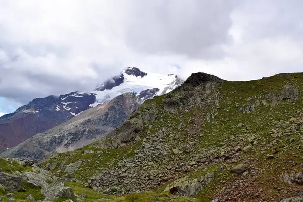Dağ manzarası, karlı zirveler, bulutlu gökyüzü