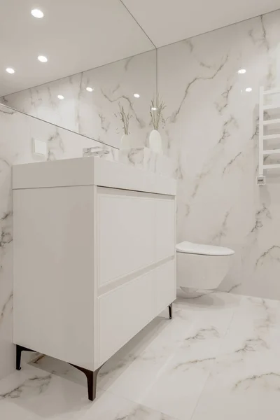 大理石のスタイルのタイルと白いタップ 花瓶や壁ヒーターとモダンなミニマリストの白いバスルームのインテリアデザイン — ストック写真