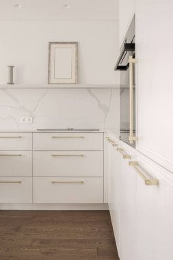 Sıcak beyaz mutfak iç tasarımı, entegre çıkarımlı elektrikli hob. Modern mutfak iç konsepti