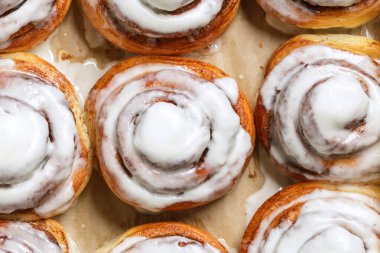 Freshly baked homemade Cinnamon rolls or Cinnamon buns on baking paper. Full frame shot