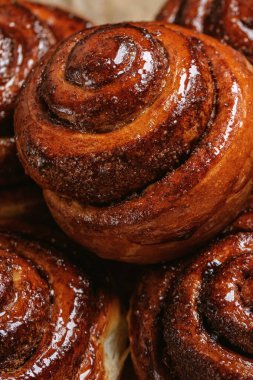 Freshly baked homemade Cinnamon rolls or Cinnamon buns on baking paper. Full frame shot