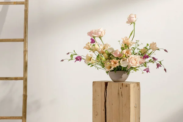 Fresh cut flower arrangement on wooden stump in a vase for decoration for home, for interiors.Flowers delivery concept. Spring concept