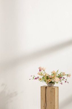 Ev dekorasyonu ve iç dekorasyon için vazodaki ahşap kütüğe yeni kesilmiş çiçek aranjmanı. Çiçek teslimatı konsepti. Bahar konsepti