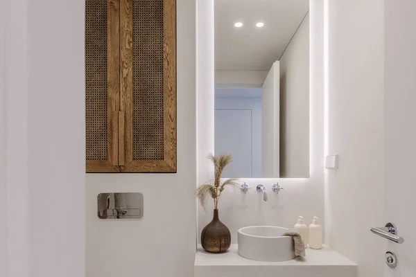 Estetik wabi sabi banyo iç tasarımı. Kahverengi ve beyaz gölgeli, meşe ve rattan mobilyalı. Banyoda mikroçimento. Yavaş yaşam konsepti