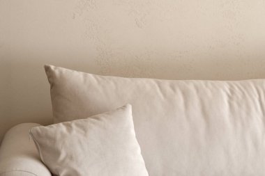 Kanepe detayı, killi duvara karşı toprak tonuyla yastık. Wabi-sabi iç mekan kavramı