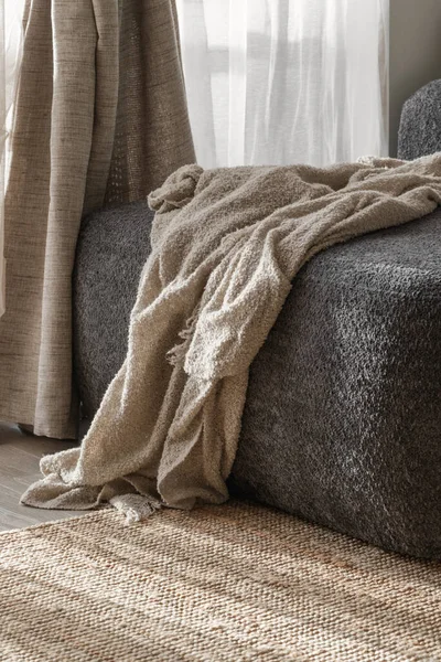  Koyu gri bir kanepede sıcak örülmüş battaniye. Wabi-sabi iç dekorasyon ayrıntıları
