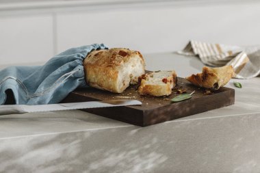 Tahtada dilimlenmiş ekmek, keten çanta ve paslanmaz mutfak bıçağı. Mutfak estetiği konsepti