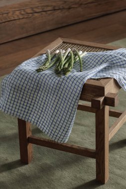 Keten çay havlusuyla rattan taburede taze kuşkonmaz. Sağlıklı yaşam tarzı kavramı