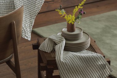  Taburede seramik yemek takımı keten çay havlusu, yaban bahar çiçekleri. Ev dekorasyonu kavramı