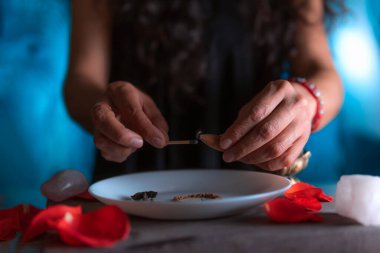 Tütsü yakan ellerin yakın çekimi, ölüler gününde cadı temizleme ritüeli yapıyor, Cadılar Bayramı, ruhani inanışlar, beyaz büyü.