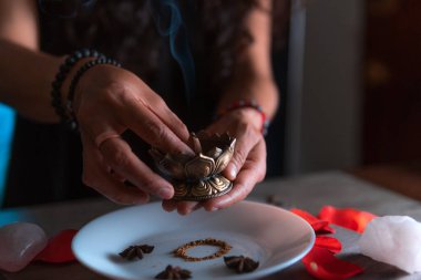 Tütsü yakan ellerin yakın çekimi, ölüler gününde cadı temizleme ritüeli yapıyor, Cadılar Bayramı, ruhani inanışlar, beyaz büyü.