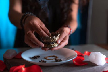 Tütsü yakan ellerin yakın çekimi, ölüler gününde cadı temizleme ritüeli yapıyor, Cadılar Bayramı, ruhani inanışlar, beyaz büyü.