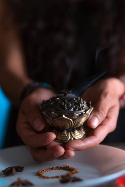 Tütsü yakan ellerin yakın çekimi, ölüler gününde cadı temizleme ritüeli yapıyor, Cadılar Bayramı, ruhani inanışlar, beyaz büyü.