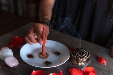 Tarçınlı kırmızı bir mumun hazırlanması, tüm azizlerin arifesinde bir aşk ritüeli gerçekleştiren cadı, cadılar bayramı, ruhani inançlar, beyaz büyü