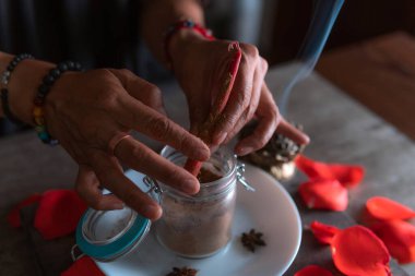 Tarçınlı kırmızı bir mumun hazırlanması, tüm azizlerin arifesinde bir aşk ritüeli gerçekleştiren cadı, cadılar bayramı, ruhani inançlar, beyaz büyü