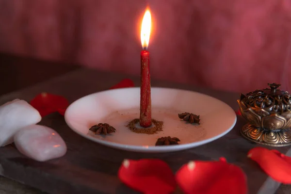 Pembe bir zeminde kırmızı bir mum, tütsü ve gül kuvars ile hazırlanmış tarçın, kopya macunu, Cadılar Bayramı, ruhani inançlar, beyaz büyü