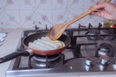 Kızartma tavasında altın taco hazırlamak, Meksika tacoları kızartmak, Meksika mutfağında ön planda görülmek üzere.