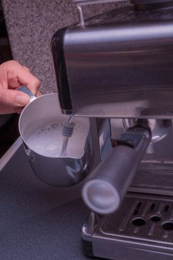 Kadın Barista kahve makinesini kullanarak nefis bir kahve hazırlamak için makineyi çalıştırıyor..