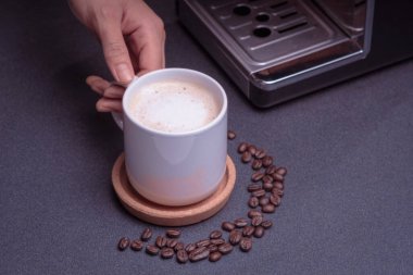 Barista kadın kahve makinesini çalıştırıyor. Kahve çekirdeği ve fotokopi alanı olan ahşap bir masada hazırlanan kapuçino kahvesi.