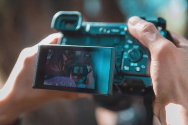 Profesyonel fotoğraf makinesi tutan kadın parkta fotoğraf çekiyor. Bir şeye odaklanıyor. Fotoğrafçılar günü konsepti..