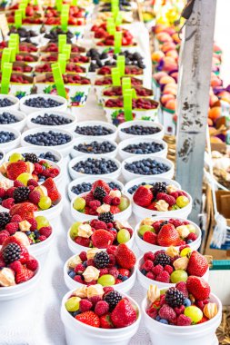 Çiftçi pazarında çok çeşitli meyveler var. Taze çilek, yabanmersini ve ahududu..