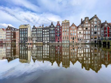 Amsterdam Damrak Kanalı 'ndaki geleneksel Hollanda mimari binaları. Suyun üzerindeki binaların yansıması.
