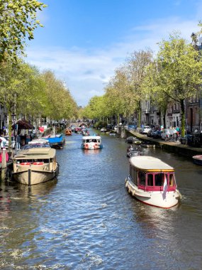 Amsterdam 'ın kanalında tekne turları. Geleneksel Hollanda evleri. Amsterdam 'ın tipik manzarası.
