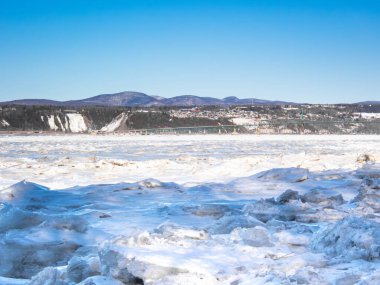 St. Lawrence nehrinde yüzen buz, Orlean 'in ada köprüsü manzaralı ve Montmorency arka planda kalıyor. Fotoğraf Orlean Adası 'ndan çekildi..