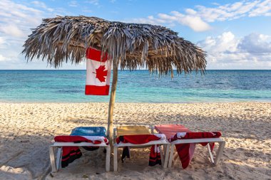 Transat, Palapa and Canadian flag on the beach of Guardalavaca, Holguin, Cuba clipart