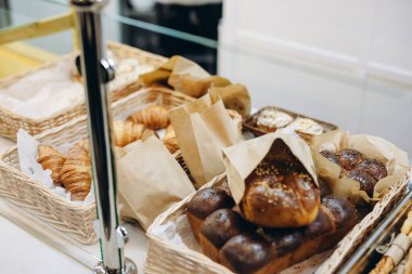 Fırıncı servis edilecek hamur ürünlerini masaya koydu. Ekmek ürünleri fırının müşterilerine satılmaya hazır. Ziyaretçilere satılacak bir sürü hamur ürünü var..