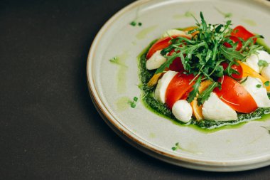 Şef yemeği ziyaretçilere servis etti. Tabakta bir tabak var. İçinde biraz yeşil, domates ve yumurta dilimleri olan bir salata var. Lezzetli görünüyor..