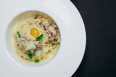 Kızarmış yumurta ve spagetti içeren yeni bir yemek görebiliriz. Usta aşçı restoranın ziyaretçilerine beyaz bir kase spagetti servis etti. Lezzetli görünüyor. İçinde biraz et de var. Servis edilmeye hazır. Lezzetli görünüyor..