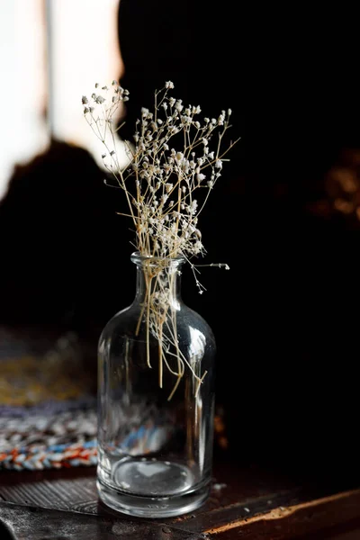 Abstract glass vase with a bouquet of dried flowers in it