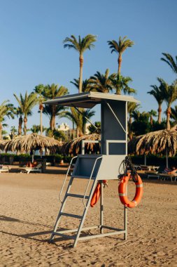 Yaz manzarası - deniz taşları ve sahil kurtarma kulübesi olan plaj. Konsept: neşe, mutluluk, pozitiflik, rahatlama, tatil, turizm.