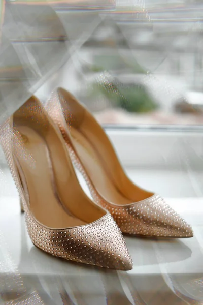 stock image wedding gold shoes on the windowsill. stylish wedding photo detail of the bride's morning